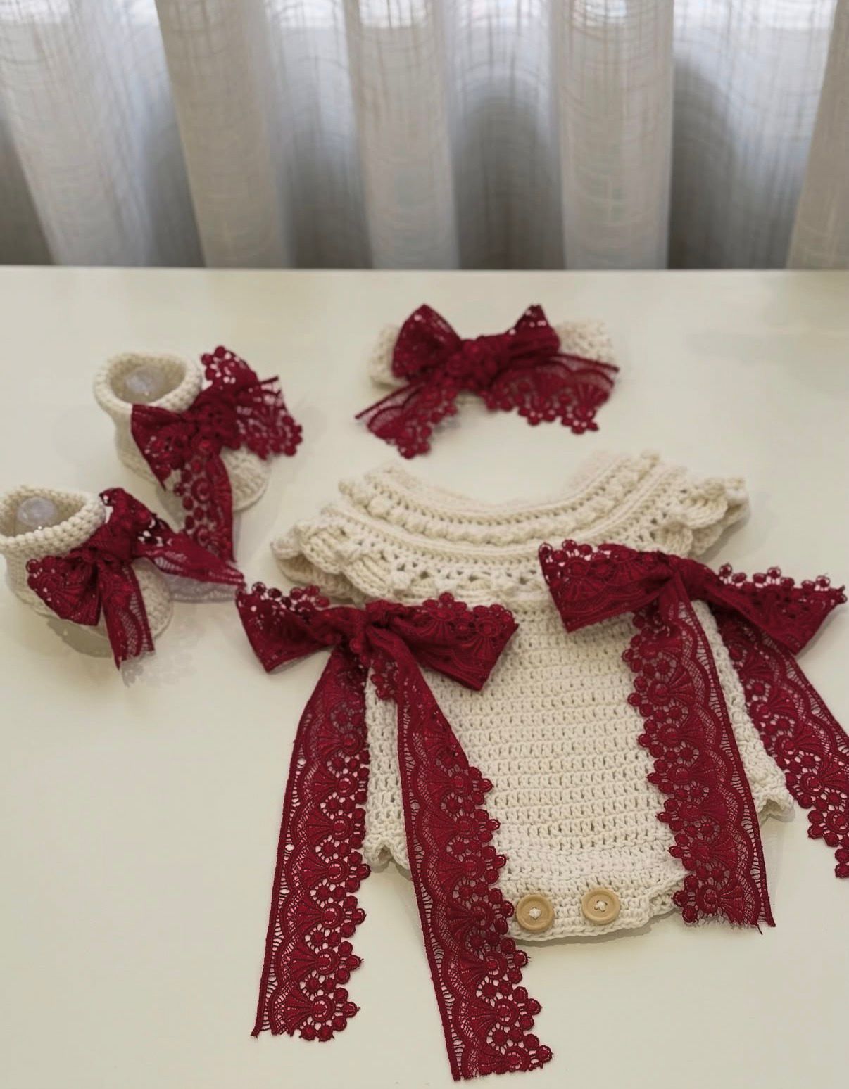 طقم مواليد كروشيه مع فيونكات دانتيل باللون الاحمر